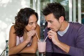 young couple sharing milk shake